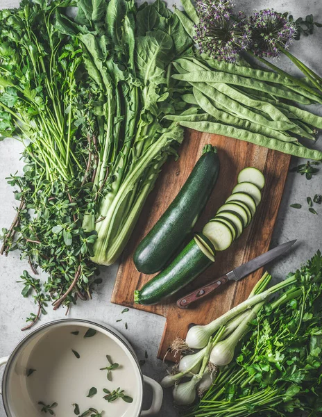 绿色健康蔬菜和香草配料 用于切菜板上的素食烹调和带有空锅的乡村厨房餐桌 顶部视图 — 图库照片
