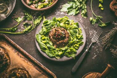 Lezzetli düşük karbonhidratlı yemek. Yeşil salata tabağında servis edilen kızarmış sebzelerle simit şeklinde kıymalı köfte. Üst görünüm