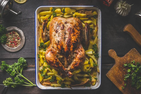 美味的烤全鸡或火鸡与土豆在黑暗的乡村木桌上 香草和香料 顶部视图 家庭烹饪 — 图库照片