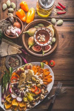 Çeşitli taze ve turşulu sebzelerle kaplı humus tabağı. Sağlıklı atıştırmalık ya da vejetaryen yemeği. Üst görünüm