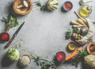 Gri beton mutfak masasında çeşitli sağlıklı sebzeler, baharatlar ve çatal bıçaklarla besin arkaplanı. Plastik poşetli mevsimlik sebzeler. Üst görünüm