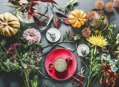 Sonbahar çiçekleri hazırlıkları karanlık masa üzerinde mumlar, balkabakları ve çiçekli köpüklerle yapılıyor.