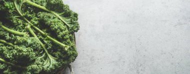 Gri beton masada çiğ yeşil lahana yapraklı yemek arkaplanı. Sağlıklı mevsimlik kış lahanalarıyla yemek pişirmek. Üst görünüm.