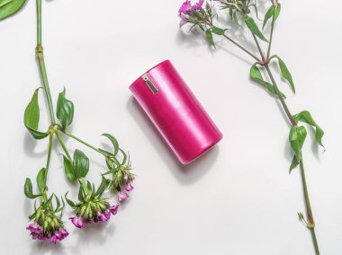 Beyaz arka planda pembe çiçekli pembe kozmetik ürünü. Üst Manzara. Doğal Kozmetik.