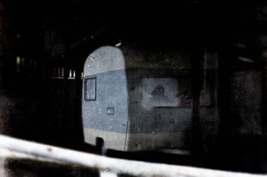Ürkütücü, sahipsiz bir binada terk edilmiş bir karavan fikri. Gözleri parlayan bir hayaletle. Bir grunge, doku düzenleme ile.