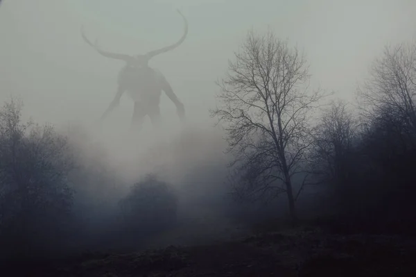 一个幻想的概念一个角形的神就像怪物 寒冷的冬日 带着毛茸茸的雾穿过森林 图库图片