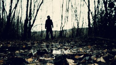 Parlayan gözleri olan doğaüstü bir figür gibi. Ürkütücü bir ormanda dikiliyorum. Bir kış günü. Bulanık, grunge vintage düzenleme ile