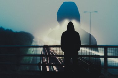 Otobanın üzerinde duran gizemli ve ürkütücü bir şahsın iki kez görüntüsü. Sisli bir gecede. Karamsar bir düzenleme ile.