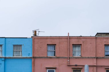 Colourful but neglected painted buildings, with weathered and deteriorated exterior. clipart