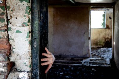 Gizemli, terk edilmiş bir evde, kapı çerçevesinde beliren ürkütücü bir el..