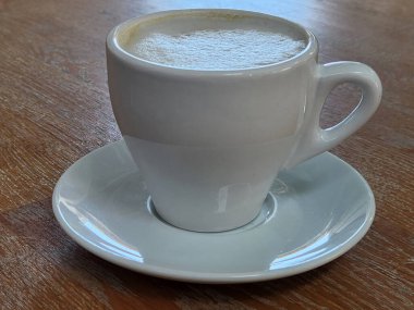 Sabah kahvesi. Beyaz bardak ve demlenmiş kapuçino. Köpüklü kahve.
