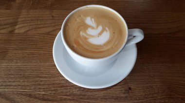 Kahve fincanda. Tahta bir masada bir fincan kahve.