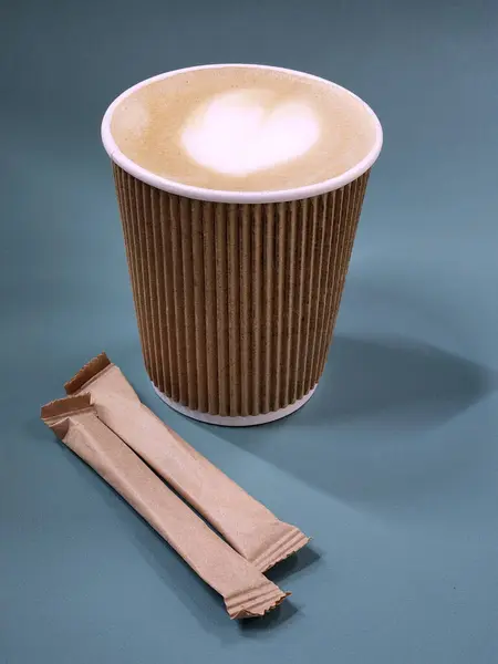 Coffee in a paper cup. Paper cup with coffee and sugar