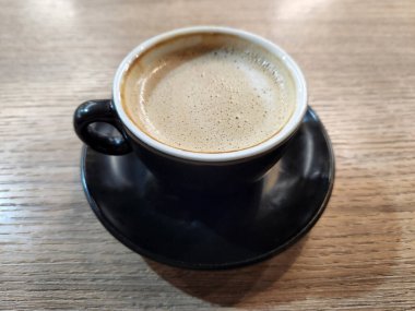 Koyu kahve ve demlenmiş kahve. Masada bir fincan kahve var.