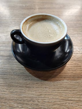 Koyu kahve ve demlenmiş kahve. Masada bir fincan kahve var.