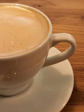 Masanın üzerinde bir fincan kahve. Kahve fincanda demlendi.