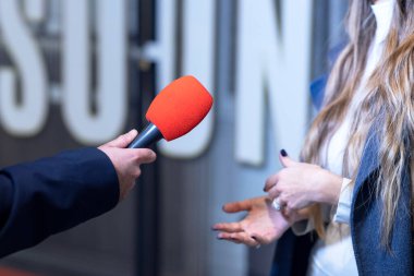 TV muhabiri tanınmayan bir kadınla röportaj yapıyor.