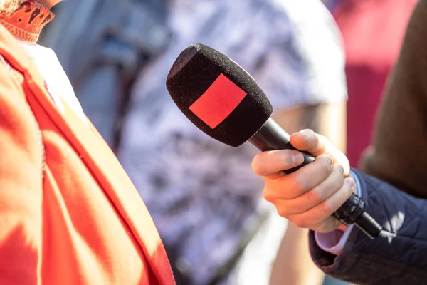 stock image Reporter holding microphone making media interview. Street interview or vox popoli.