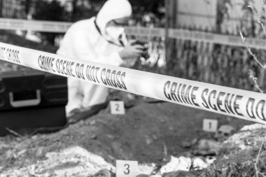 Olay yeri inceleme. Adli tıp uzmanı insan kalıntıları üzerinde çalışıyor..