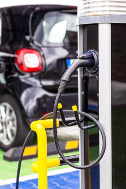 Şarj istasyonunda prize takılı elektrikli araba şarj oluyor.