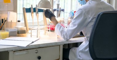 Kimyasal ya da mikrobiyoloji laboratuvarında biyokimyasal örnekleri analiz eden bir teknisyen. Otantik retro tıbbi araştırma laboratuvarı.