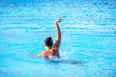 Sanatsal ya da senkronize yüzücü yüzme havuzunda koreografisini yapıyor.