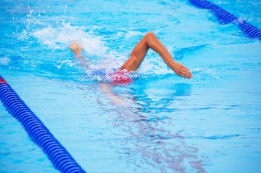 Unrecognizable male swimmer swimming freestyle in outdoor Olympic-sized swimming pool clipart