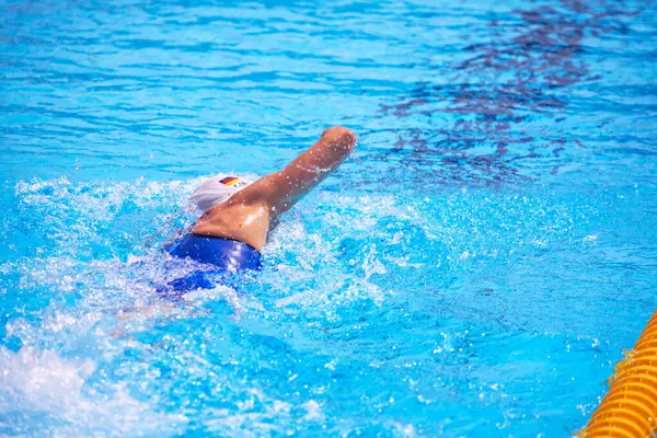 stock image Unrecognizable female swimmer swimming freestyle  in outdoor Olympic-sized swimming pool