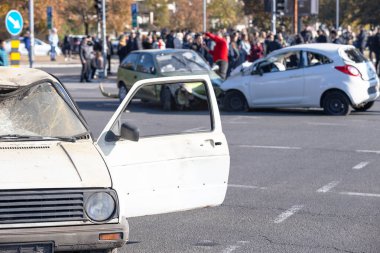 Yoğun bir şehir kavşağında, hasarlı araçlar ve kalabalığın gözlediği ciddi bir çoklu araba kazası.
