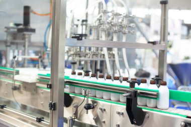 Modern bir endüstriyel tesiste sıvı ürünleri şişelemek ve paketlemek için otomatik üretim hattı