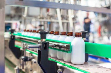 Modern bir endüstriyel tesiste sıvı ürünleri şişelemek ve paketlemek için otomatik üretim hattı