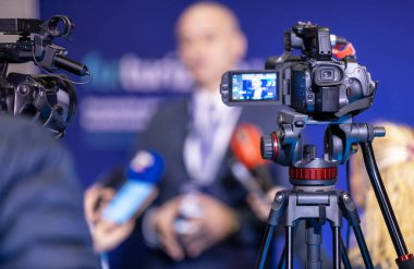 TV kameraları önünde basın toplantısı ya da medya röportajı yapan bulanık bir konuşmacı