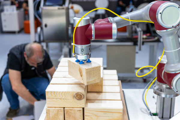 Collaborative robot or robotic arm handling wooden blocks in automated manufacturing process