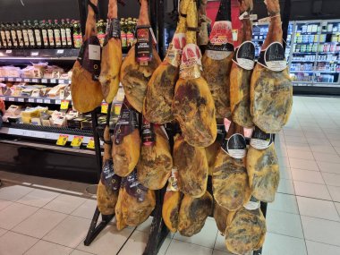Geleneksel İspanyol et ürünlerinden tütsülenmiş bir sürü bacak. Pazarda jambon satışı. BARCELONA, İSPAN - 16 Kasım 2022: