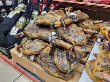 Geleneksel İspanyol et ürünlerinden tütsülenmiş bir sürü bacak. Pazarda jambon satışı. BARCELONA, İSPAN - 16 Kasım 2022: