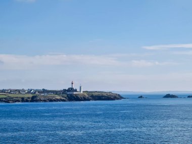 Sahildeki deniz feneri Gökyüzü ve mavi deniz arka planıyla