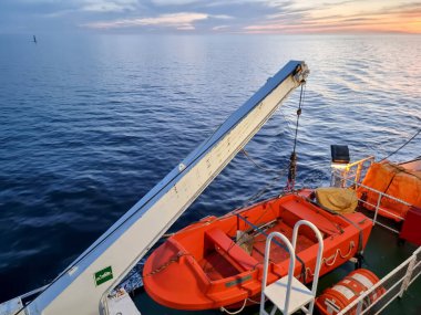 Turuncu bir cankurtaran botu vinçle suya yanaştı.
