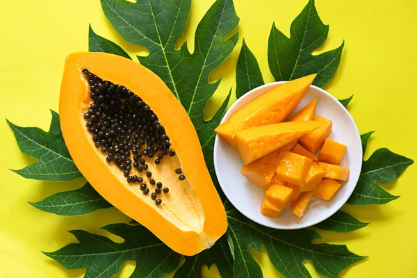 Stock image papaya fruits on yellow backgroud, fresh ripe papaya slice tropical fruit with papaya seed and leaf leaves from papaya tree - top view