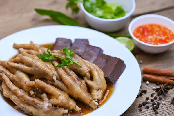Thai food, chicken feet soup stewed, cooking chicken feet foot stew on white with herbs and spices ingredients with chilli lemon vegetable on wooden background, Asian chinese food menu stew