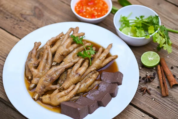 Thai food, chicken feet soup stewed, cooking chicken feet foot stew on white with herbs and spices ingredients with chilli lemon vegetable on wooden background, Asian chinese food menu stew
