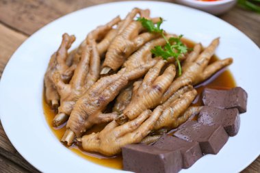 Tavuk ayağı çorbası pişirilmiş, tavuk ayağı güveci pişirilmiş, otlu ve baharatlı, ahşap arka planda biberli, limonlu, Asya Çin yemeği menüsü güveci Tayland yemeği.