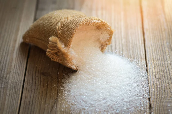 Sugar on sack and wooden background, white sugar for food and sweets dessert candy heap of sweet sugar crystalline granulated