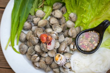 Midye kabuklu deniz ürünleri tabağında taze sebze ve baharat var. Kabuklu deniz ürünleri sosuyla kabuklu kan midyesi.