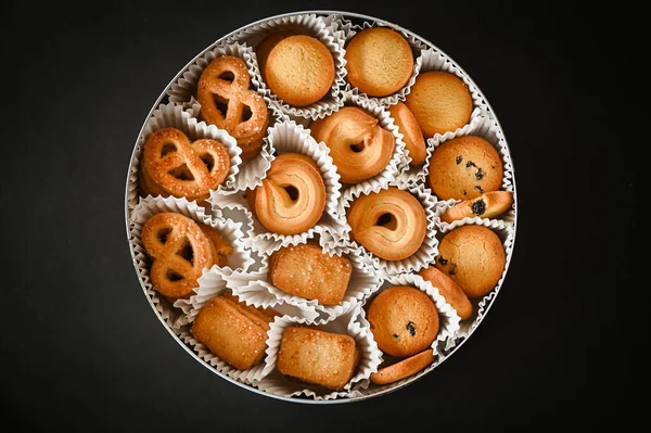 cookie box with danish butter cookies on black table background, top view