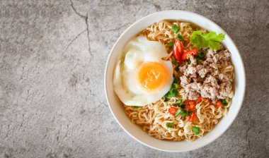 noodles bowl with boiled egg minced pork vegetable spring onion lemon on table food , instant noodles cooking tasty eating with bowl noodle soup - top view