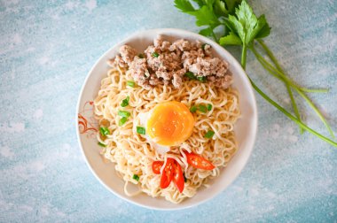 noodles plate with egg minced pork vegetable spring onion celery and chili on table food , instant noodles cooking tasty eating with bowl noodle soup - top view