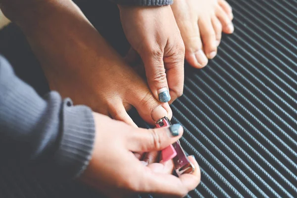 Cut toenails cut nails concept, woman hand holding nail clipper and cutting nails foot - pedicure nail health care
