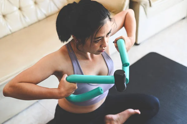 woman arm exercises  in her hands, sport recreation health care concept sporty woman exercise muscles in sportswear with dumbbell at home in the living room, woman exercising at home