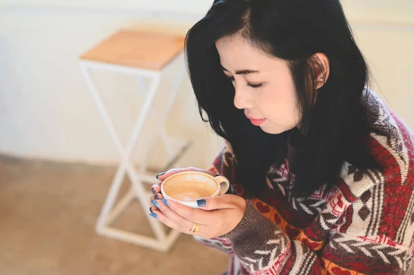 young woman drinking coffee or tea relaxed woman smelling coffee at home in winter with cup coffee, woman coffee with hand holding a cup in cafe