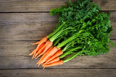 carrot on wooden table background, Fresh and sweet carrots for cooking food fruits and vegetables for health concept, baby carrots bunch and leaf